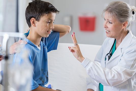 A doctor holding her fingers up for a child to look at