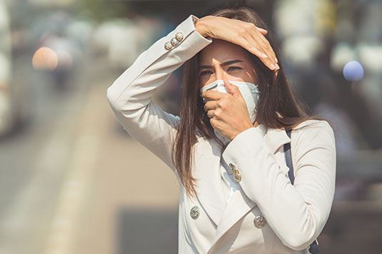 A woman with a mask on standing outside