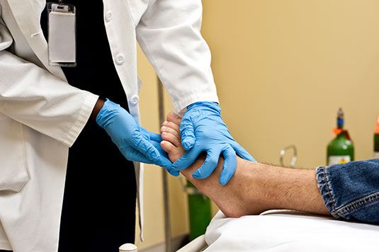 doctor checking out persons foot